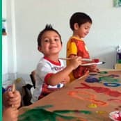 Alumnos pintando juntos en una mesa del salón