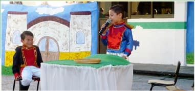 Dos alumnos representando una obra de teatro en el patio del colegio