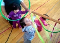 Niño pequeño en una actividad de psicomotricidad con aros de colores